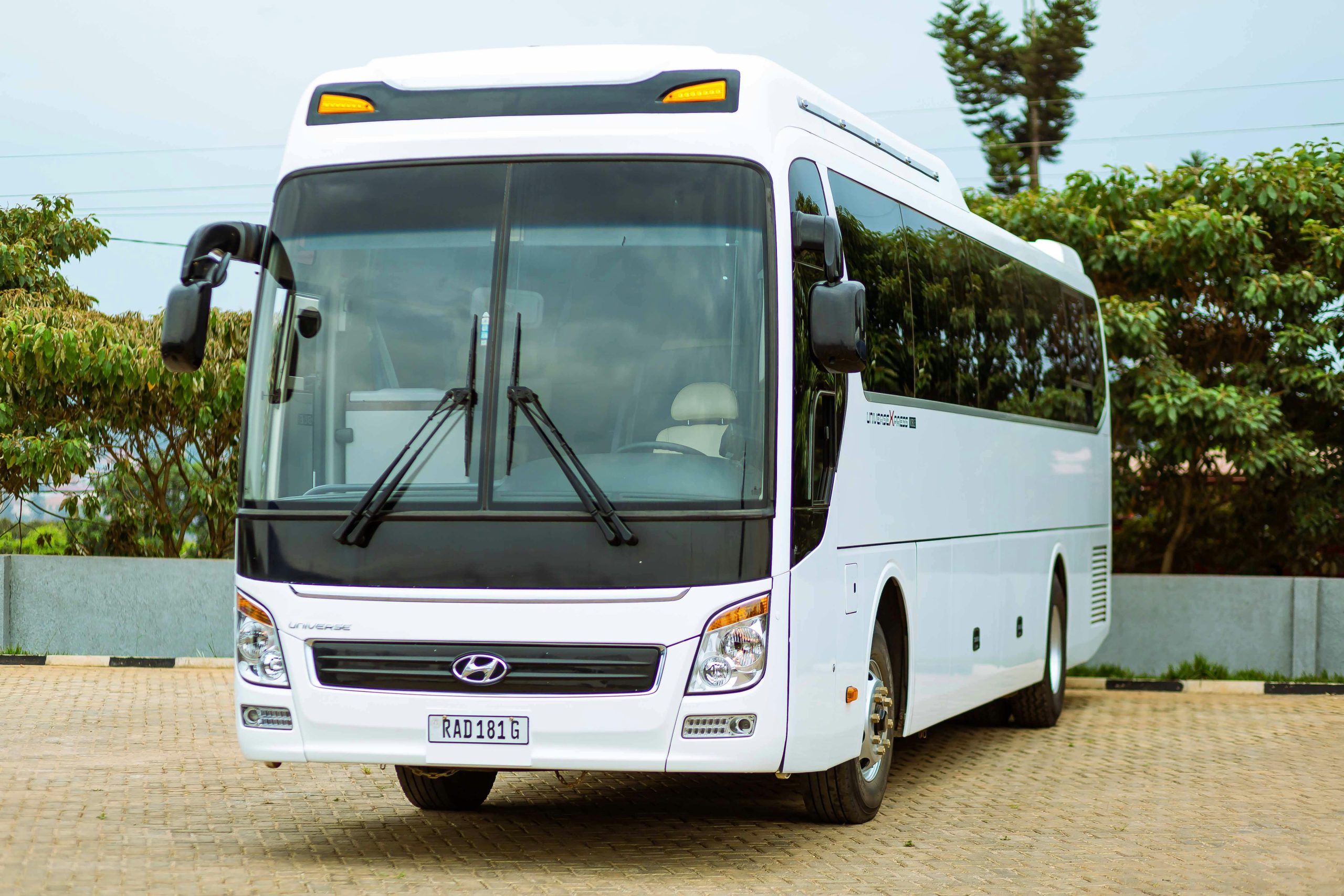 A white Hyundai bus parked outside on a paved surface, ideal for travel and transport themes.