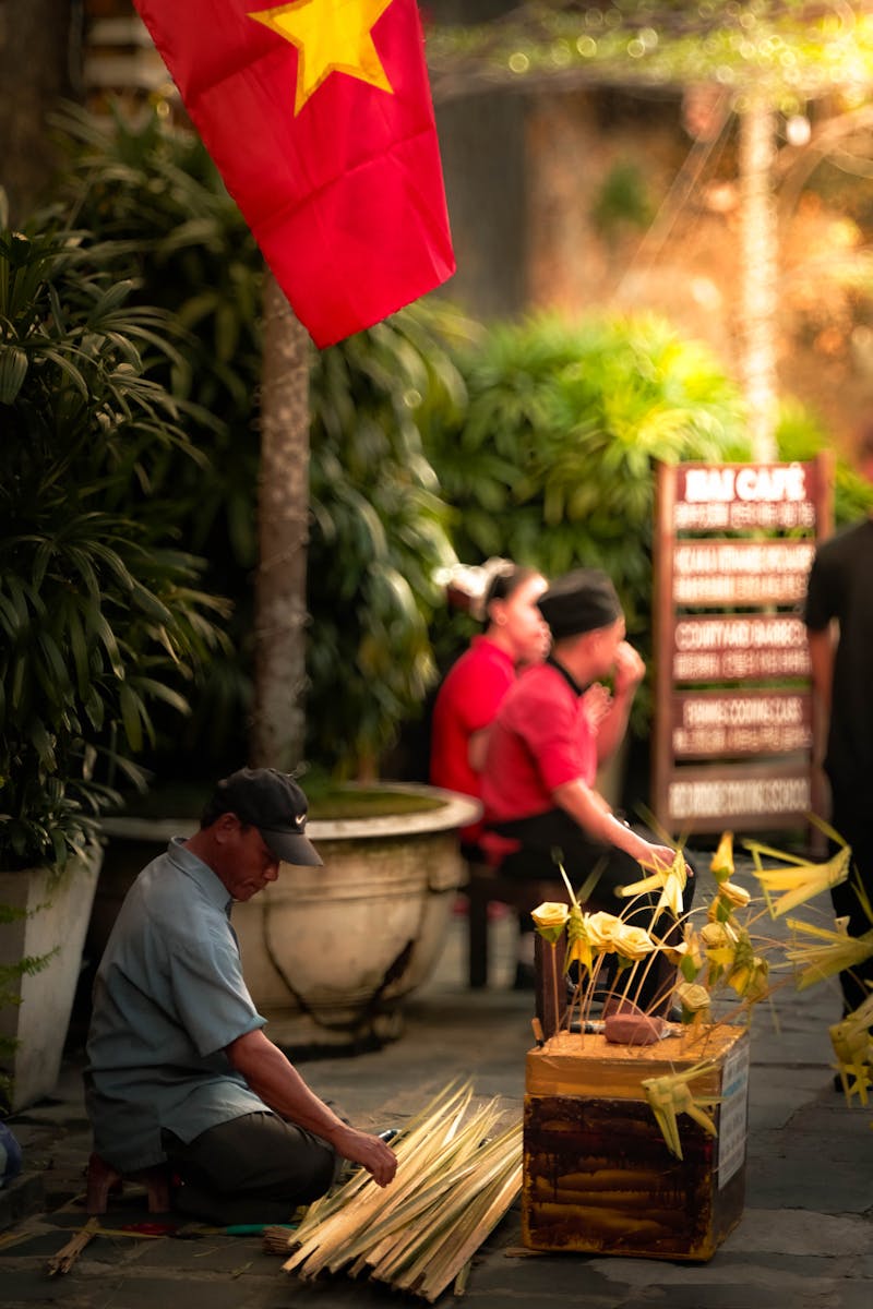 A Vietnamese artisan practices traditional craftsmanship in the vibrant streets of Hội An.